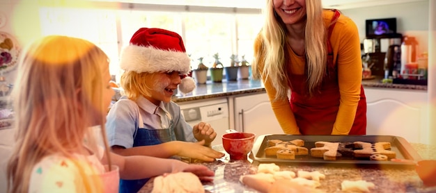 Imagem composta de parquet marrom contra família fazendo biscoitos de natal em casa