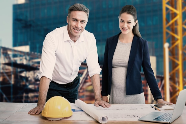 Imagem composta de retrato de arquitetos em pé à mesa