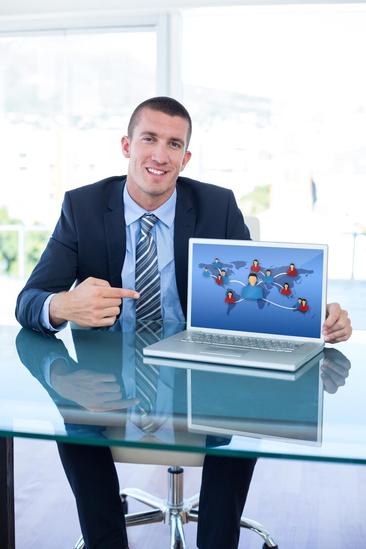 Foto imagem composta de um empresário sorridente apontando para a tela do laptop no escritório
