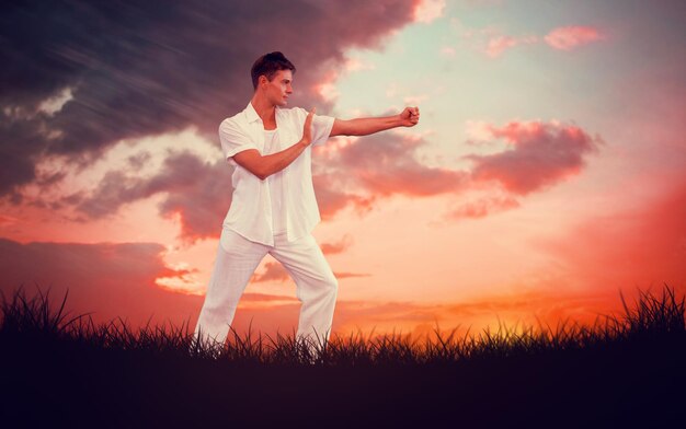 Imagem composta de um homem bonito de branco fazendo tai chi