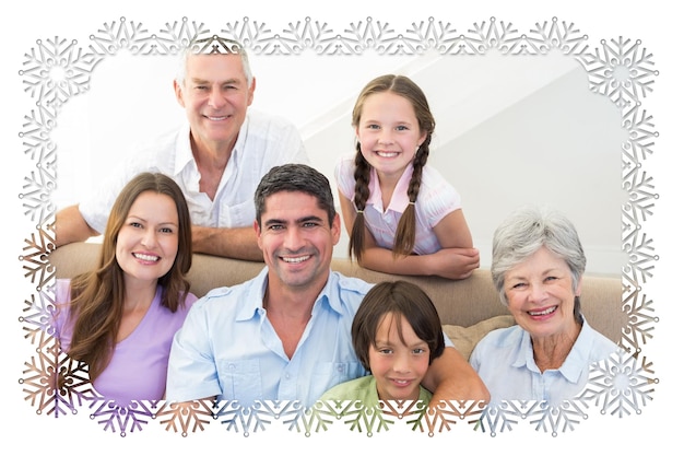 Foto imagem composta de uma família sorridente de várias gerações contra um quadro de floco de neve