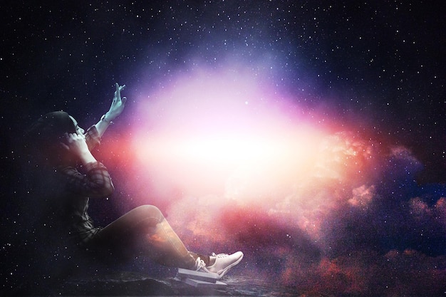 Foto imagem composta digital de mulher gesticulando contra a nebulosa no céu à noite