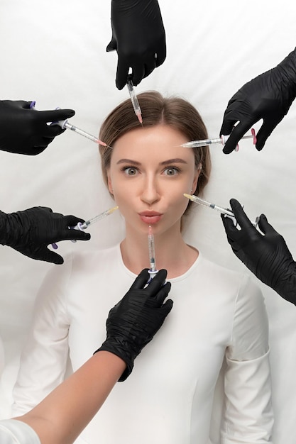 Foto imagem conceitual de beleza e cosmetologia das mãos de vários médicos segurando seringas de beleza e