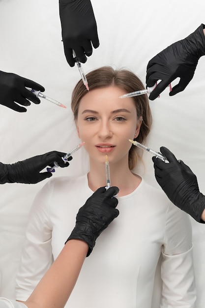Imagem conceitual de beleza e cosmetologia das mãos de vários médicos segurando seringas de beleza e