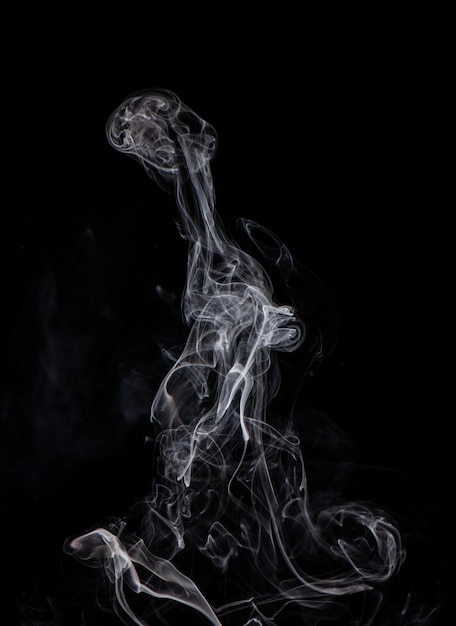 Imagem conceitual de fumaça de cor branca isolada em fundo preto escuro conceito de elemento de design de Halloween