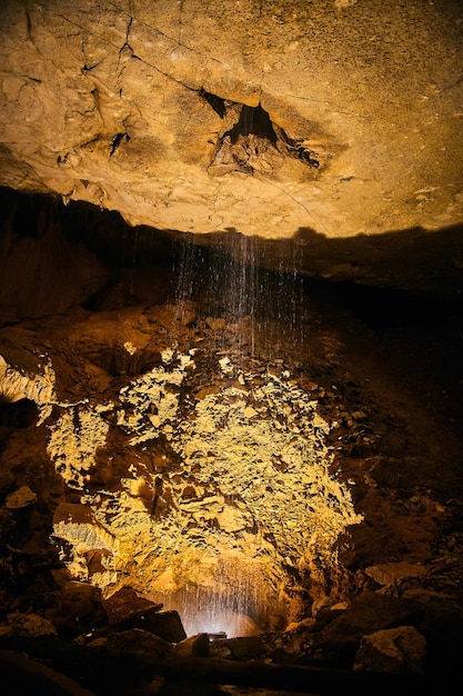 Imagem da água pingando em formações de cavernas amarelas