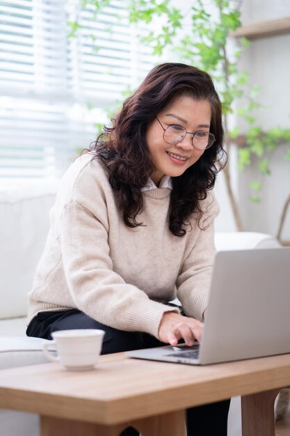 Imagem da empresária asiática sênior trabalhando em casa