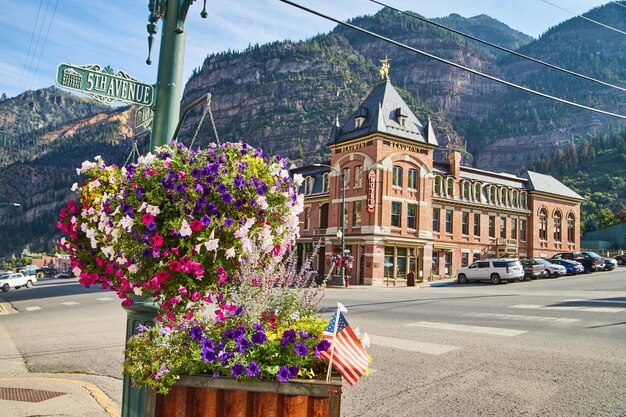 Imagem da interseção de uma cidade na montanha com flores penduradas e em vasos