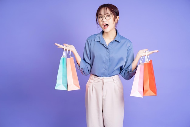 Imagem da jovem empresária asiática segurando a sacola de compras
