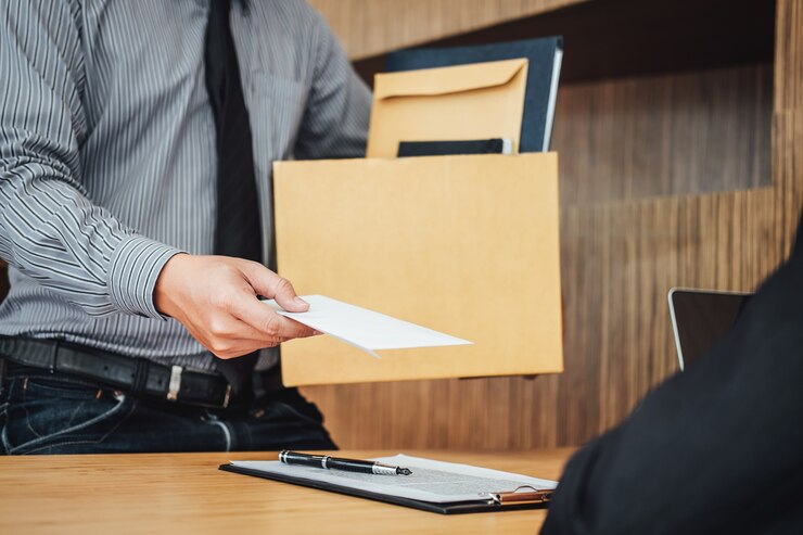 Foto imagem da mão do homem de negócios que guarda a caixa de cartão e que envia uma carta de demissão