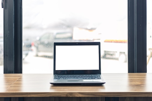 Imagem da maquete de laptop com tela branca em branco, telefone inteligente e documento na mesa de madeira