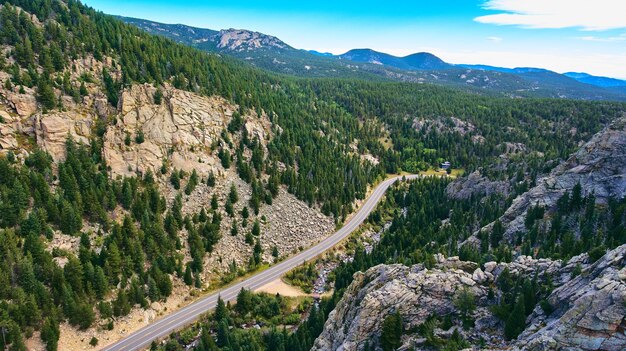 Imagem da rodovia através do desfiladeiro de montanhas rochosas e floresta de pinheiros