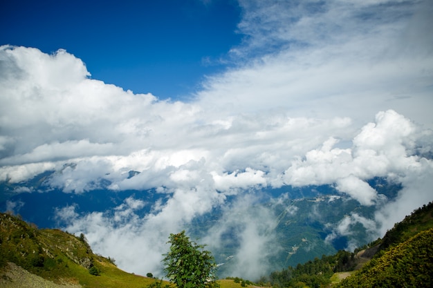 Imagem das encostas das montanhas com vegetação, céu nublado