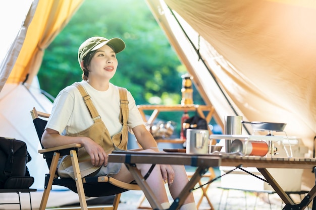 Imagem de acampamento solo - uma jovem relaxando em uma barraca