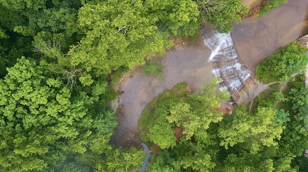 Imagem de Aerial olhando para cascatas em um rio cercado por uma floresta verde
