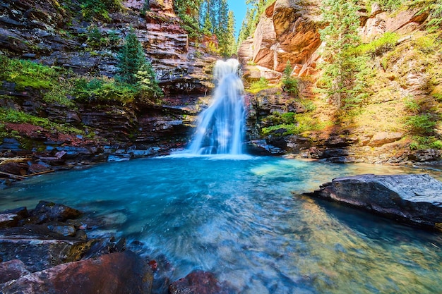 Imagem de água azul pura de uma cachoeira em um desfiladeiro escondido das montanhas