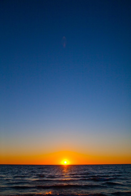 Imagem de água e céu noturno ao pôr do sol