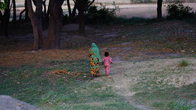 imagem de aldeões indianos Uma mulher está carregando sua filha segurando sua mão