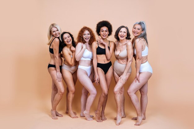 Imagem de beleza de um grupo de mulheres com diferentes idades, pele e corpo posando em estúdio para um ensaio fotográfico positivo. Modelos femininos mistos em lingerie em fundos coloridos