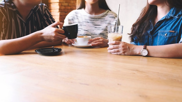 Imagem de close de amigos gostando de conversar e beber café juntos em uma cafeteria