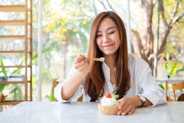 Imagem de close de uma linda mulher asiática tomando um sorvete em um restaurante