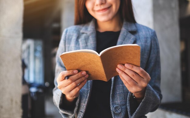 Imagem de close de uma linda mulher de negócios asiática segurando e olhando para um caderno