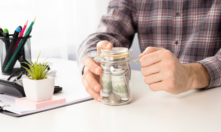 Foto imagem de close de uma mulher de negócios calculando, empilhando e colocando moedas em uma jarra de vidro para economizar dinheiro e conceito financeiro