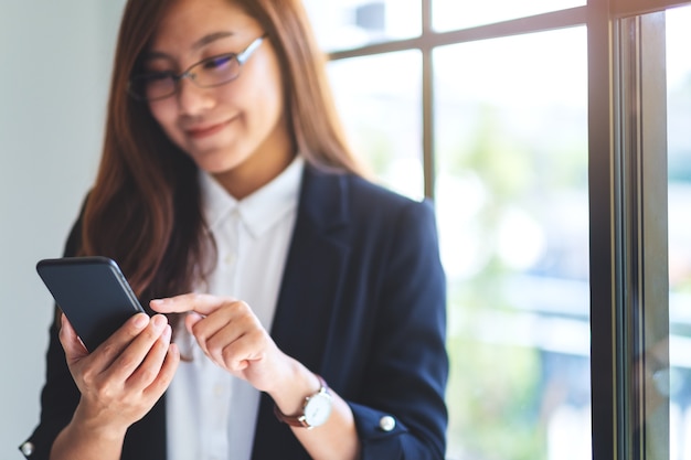 Imagem de close de uma mulher de negócios segurando e usando um telefone celular