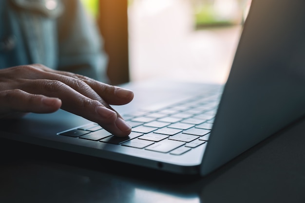 Imagem de close de uma mulher digitando e pressionando o dedo no teclado do laptop