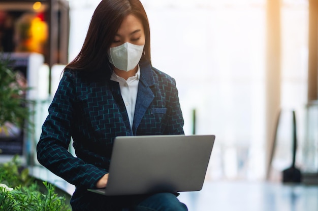 Imagem de close de uma mulher doente usando máscara protetora, usando um laptop para o conceito de saúde e Covid-19