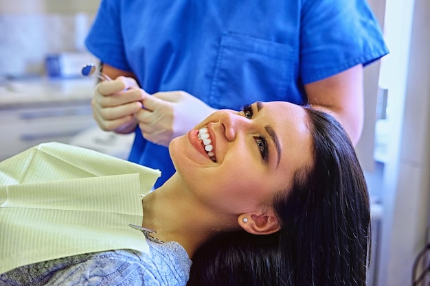 Imagem de close-up de um dentista examinando os dentes da mulher em odontologia.