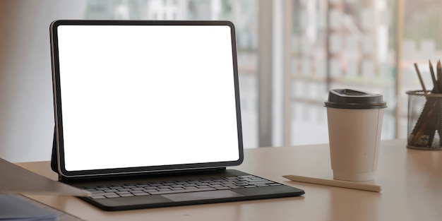Imagem de close-up de um laptop com tela em branco e material de escritório em um escritório moderno
