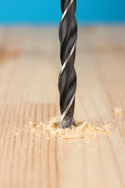 Imagem de close-up do furo em uma prancha de madeira, na cor