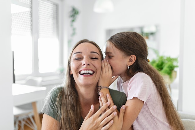 Imagem de close-up mãe espantada ouve notícias incríveis da filha pequena, menina criança compartilha segredo contando algo interessante enquanto a mãe de boca aberta se sente surpresa, confia, pessoa confidente, conceito divertido