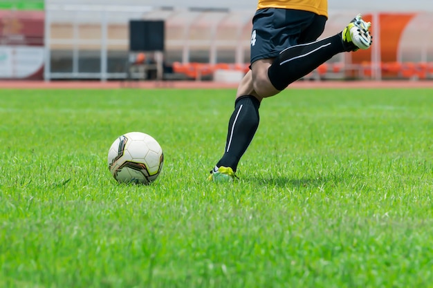 Imagem de close-up, os jogadores de futebol estão prestes a chutar a bola que é colocada no gramado.