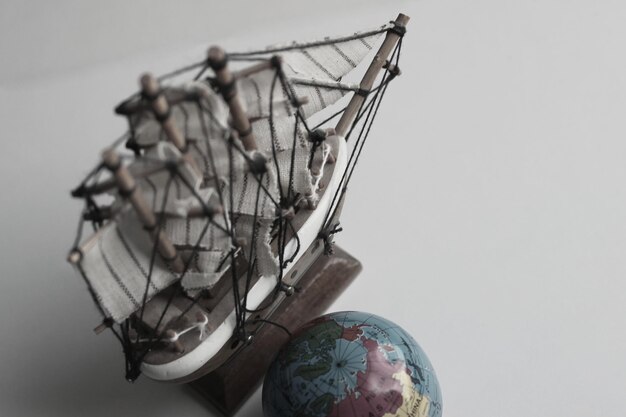 Imagem de conceito de viagem marítima Globo e modelo de madeira de velho navio em estilo de cores apagadas