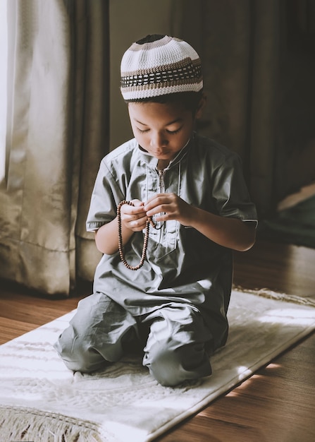 imagem de criança pré-escolar muçulmana orando a Deus Fazendo Dua ou súplica Conceito de criança muçulmana orando
