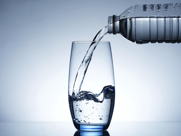 Imagem de derramar água de uma garrafa de água em um copo