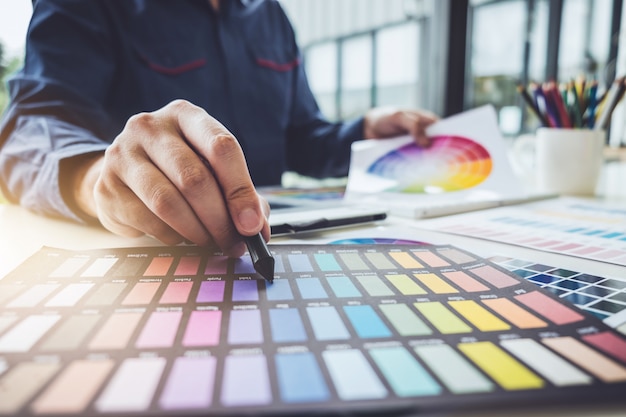 Imagem de designer gráfico criativo trabalhando na seleção de cores e desenho na mesa digitalizadora