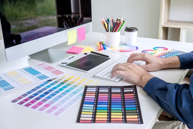 Imagem de designer gráfico criativo trabalhando na seleção de cores e desenho na mesa digitalizadora