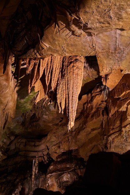 Imagem de detalhe vertical de formações de cavernas com estalactites de água pingando