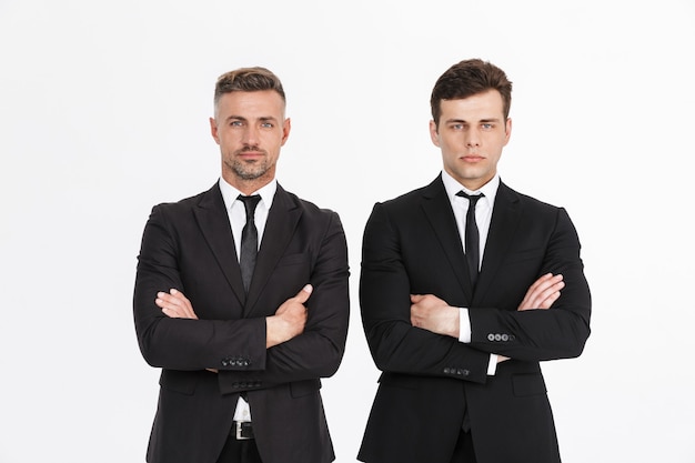 Imagem de dois homens de negócios sérios masculinos em ternos de escritório olhando com os braços cruzados isolados