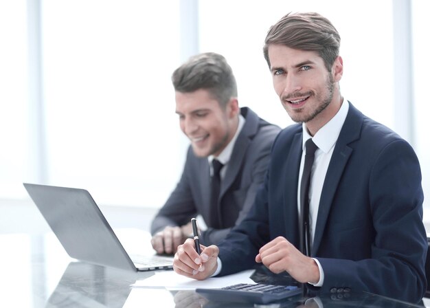 Imagem de dois jovens empresários usando laptop em reunião