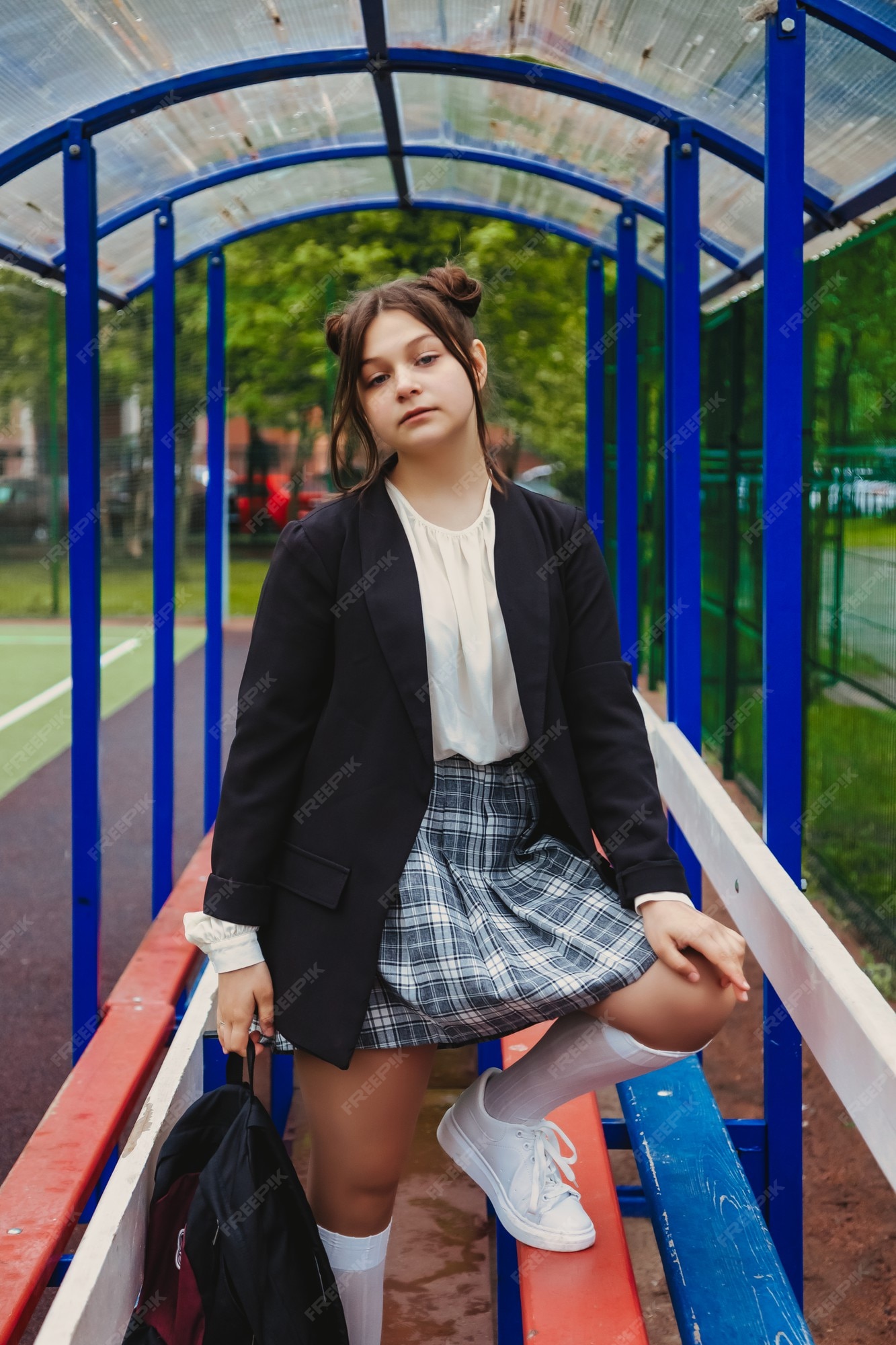 Imagem de estilo de filme de ruído de arte. retrato de uma colegial de  treze anos de blusa branca, saia xadrez e jaqueta na escola. menina  adolescente emocional posando olhando para a