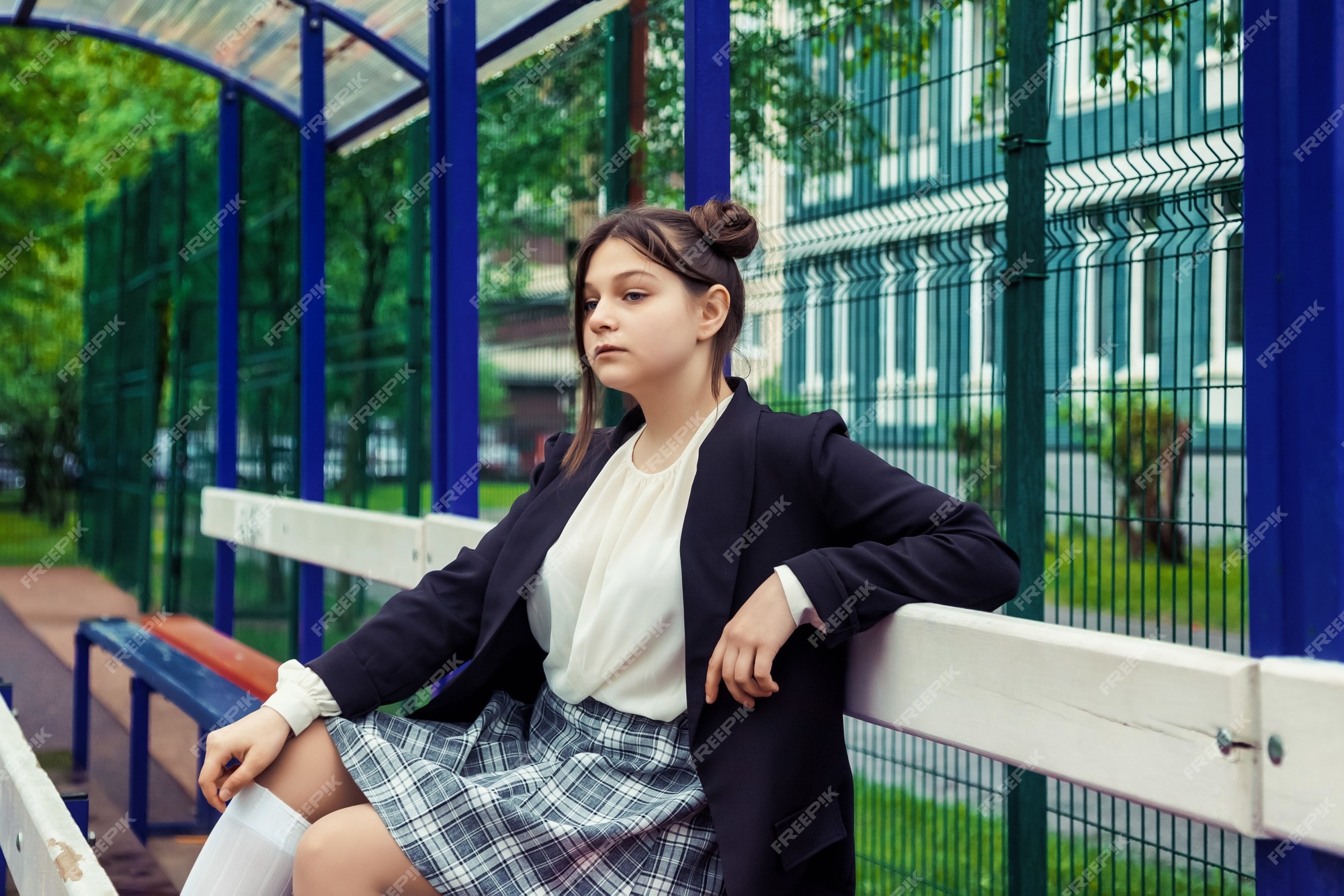 Imagem de estilo de filme de ruído de arte. retrato de uma colegial de  treze anos de blusa branca, saia xadrez e jaqueta na escola. menina  adolescente emocional posando olhando para a