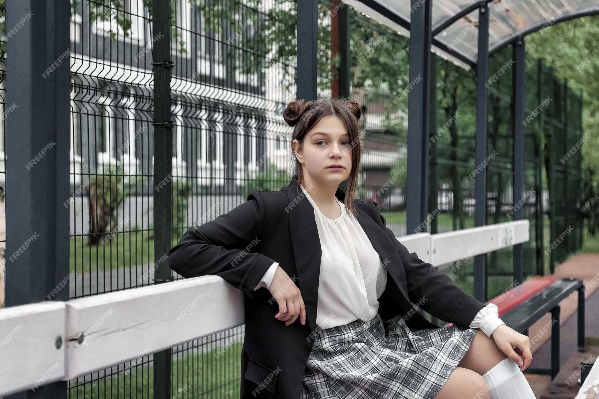 Imagem de estilo de filme de ruído de arte. retrato de uma colegial de  treze anos de blusa branca, saia xadrez e jaqueta na escola. menina  adolescente emocional posando olhando para a