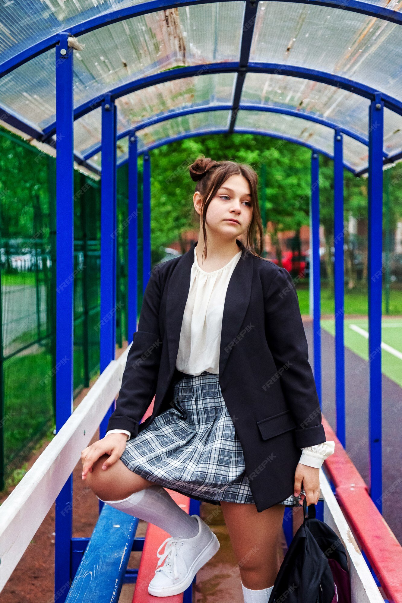 Imagem de estilo de filme de ruído de arte. retrato de uma colegial de  treze anos de blusa branca, saia xadrez e jaqueta na escola. menina  adolescente emocional posando olhando para a câmera. conceito de idade  escolar e aprendizagem