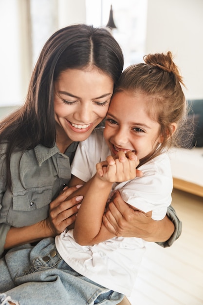 Imagem de família feliz, mãe e filha se abraçando e sorrindo enquanto descansavam em casa pela manhã