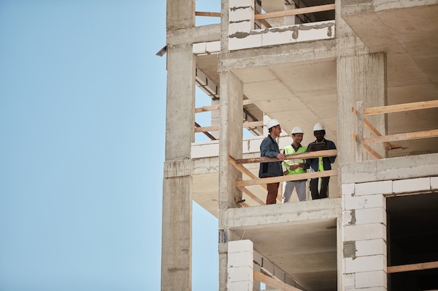 Imagem de fundo de um canteiro de obras com um grupo de trabalhadores copie o espaço