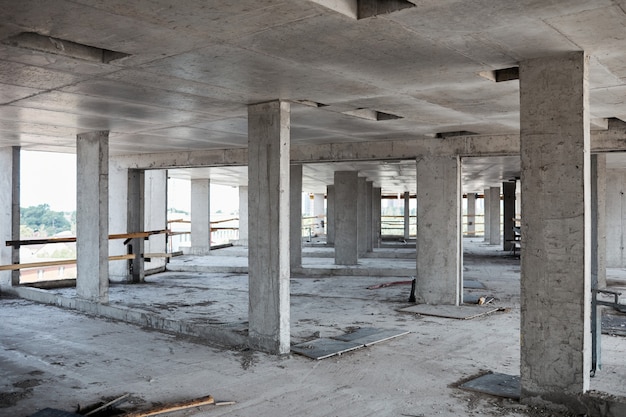 Imagem de fundo de um prédio inacabado no canteiro de obras com colunas de concreto, copie o espaço